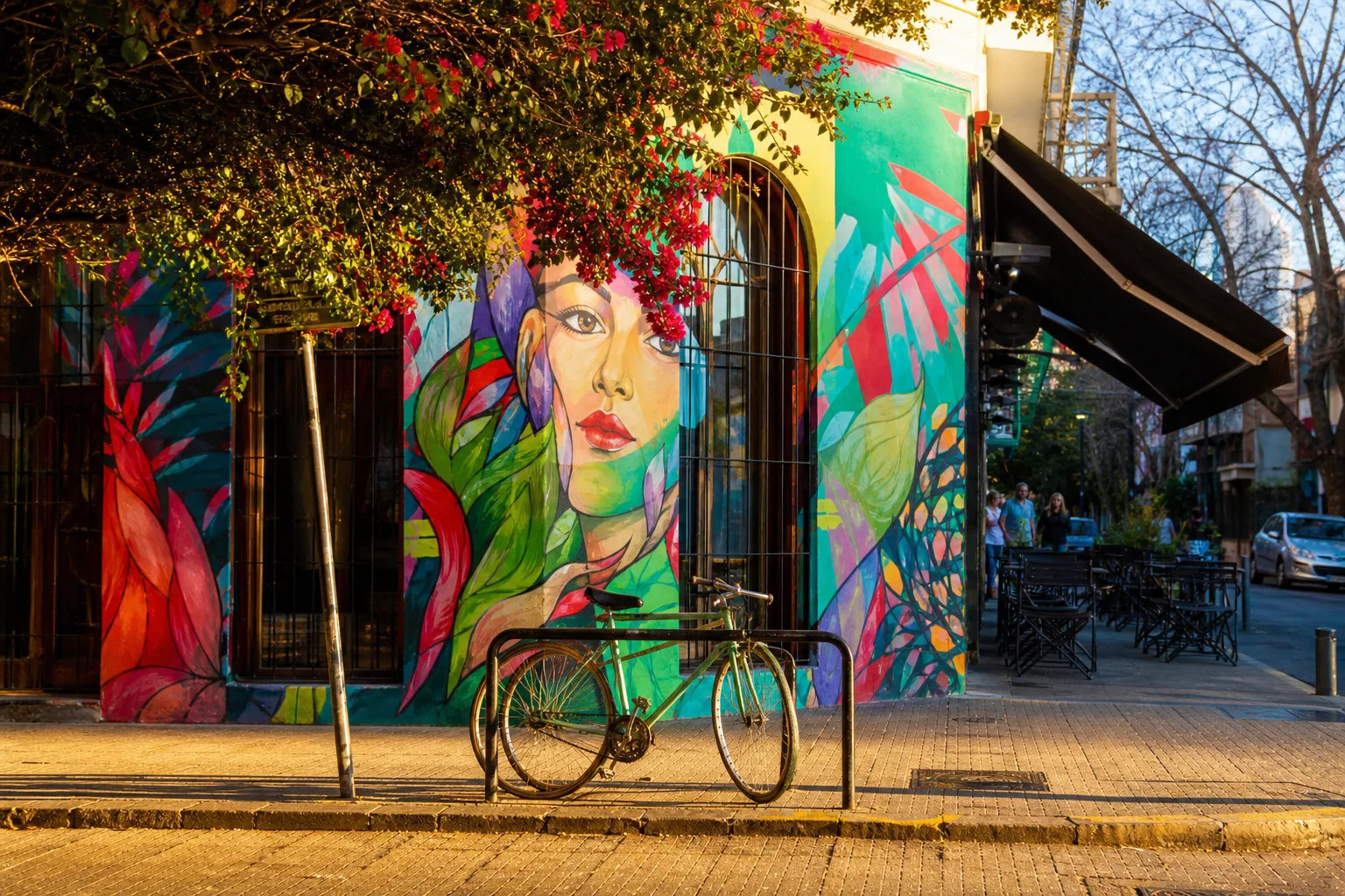 Escena de barrio con mural y vereda